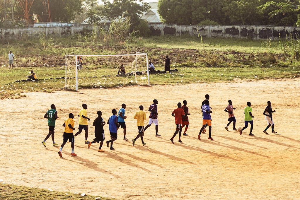 Youth Soccer Practice on Dirt Field in Sunlight