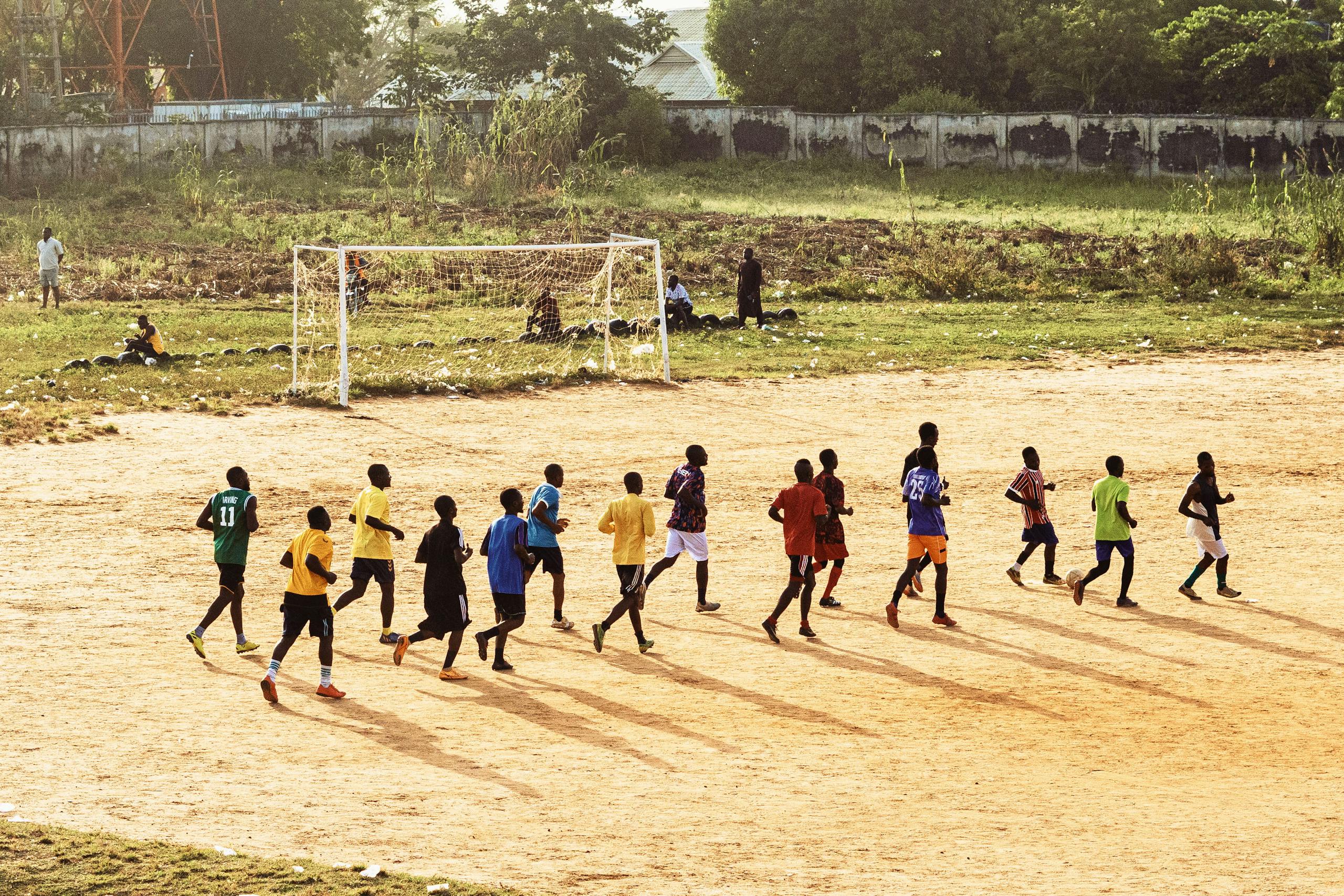 Youth Soccer Practice on Dirt Field in Sunlight